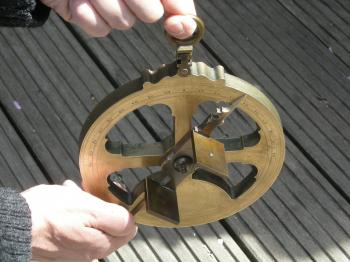 Holding the astrolabe for observations.