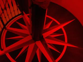 The floor at night with red illumination on looks as if the wind-rose is floating in air.